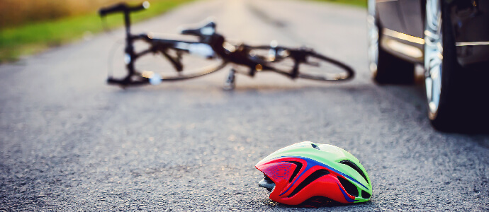 Bicycle and helmet on the road after a car hit a cyclist, bicycle accidents