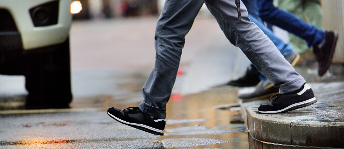 Man stepping over puddle in rain, Pedestrian