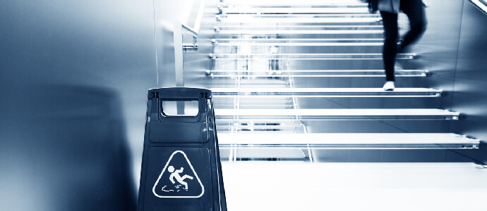 Woman walking down stair with caution sign at the bottom of stairs, Premises liability
