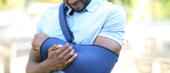 Man holding his arm in a sling, soft tissue injury