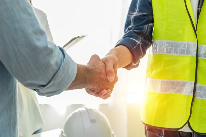 Construction worker shaking hands with personal injury attorney