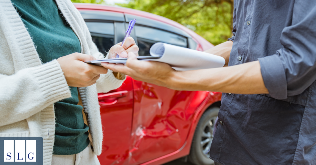 Driver documenting vehicle damage after a car accident