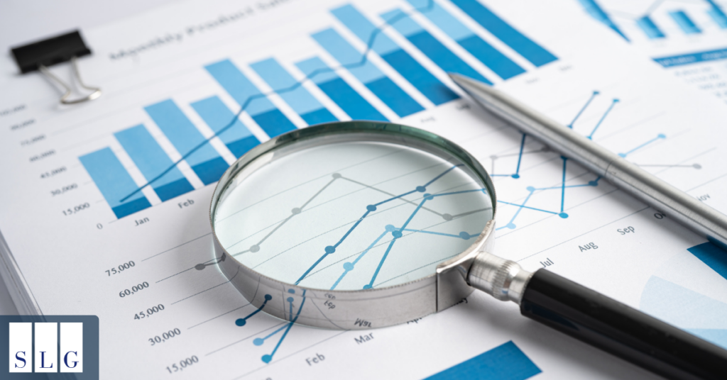 Magnifying glass over charts representing California truck accident statistics and trends.