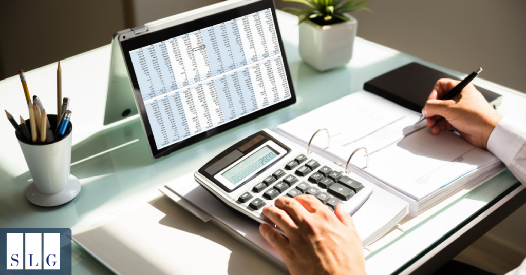 Person using a calculator and reviewing financial records to determine the value of a dog bite settlement.