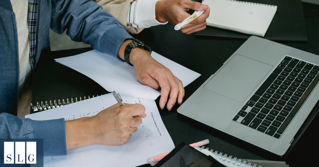 Legal professionals reviewing documents beside a laptop while preparing and evaluating a personal injury claim.